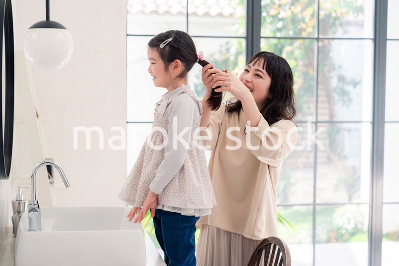 子供の髪の毛をセットするお母さん