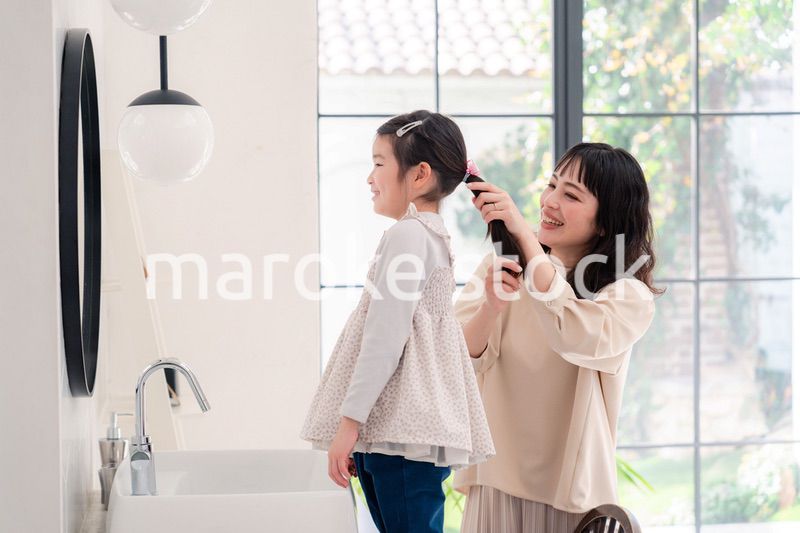 子供の髪の毛をセットするお母さん