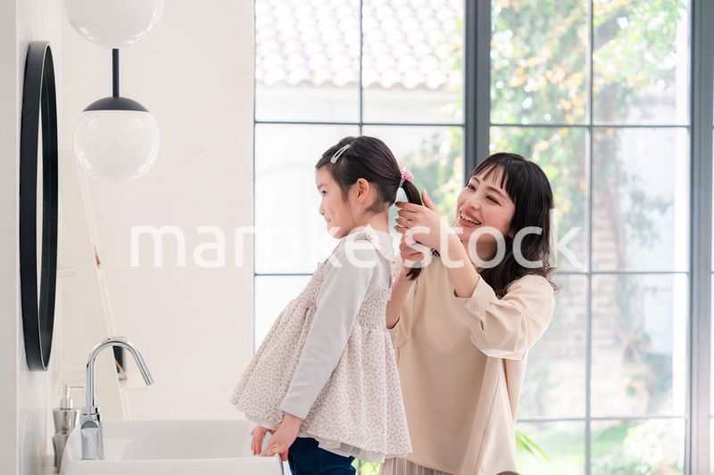 子供の髪の毛をセットするお母さん