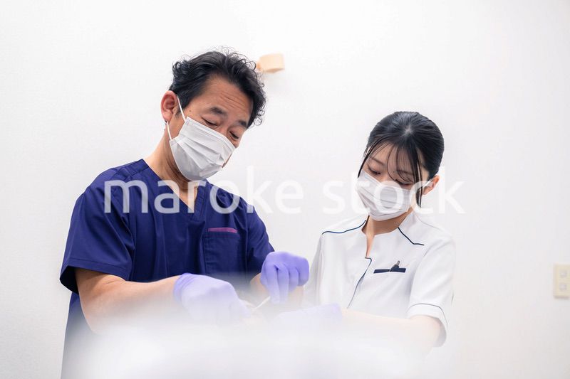 歯科治療をする歯科医師と歯科助手