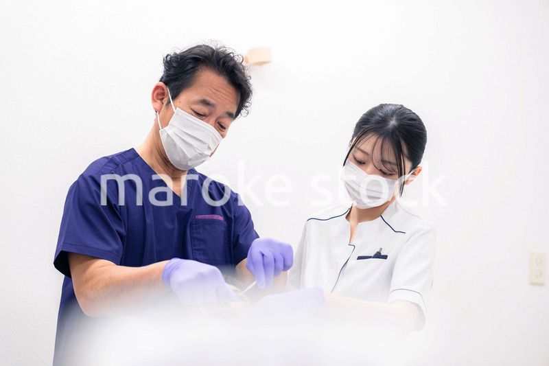 歯科治療をする歯科医師と歯科助手