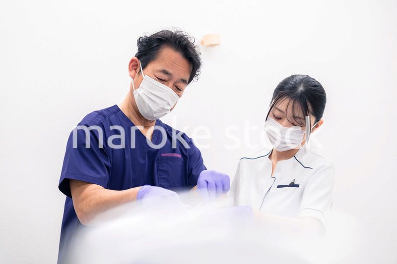 歯科治療をする歯科医師と歯科助手