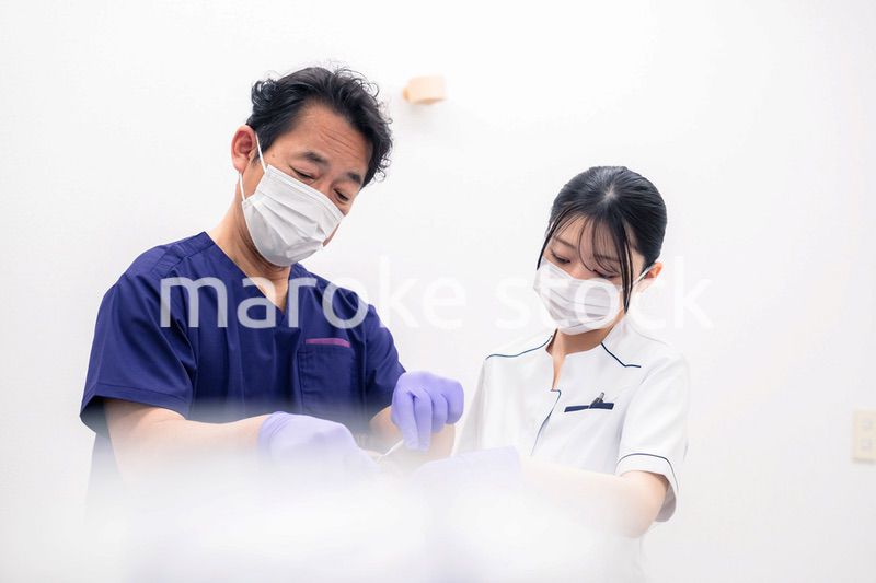 歯科治療をする歯科医師と歯科助手