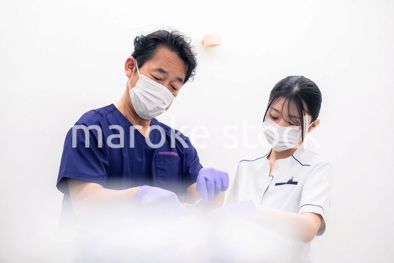歯科治療をする歯科医師と歯科助手