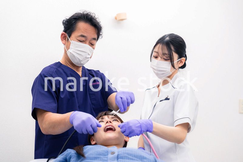 歯科治療をする歯科医師と歯科助手