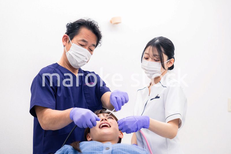 歯科治療をする歯科医師と歯科助手