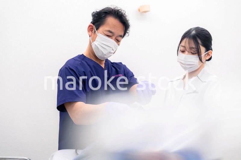 歯科治療をする歯科医師と歯科助手