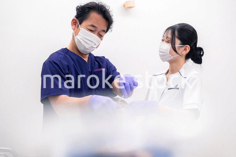 歯科治療をする歯科医師と歯科助手