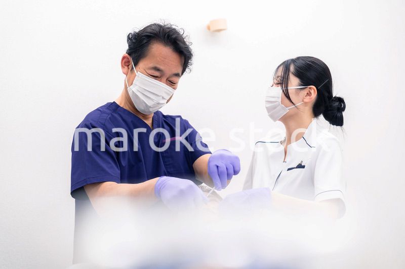 歯科治療をする歯科医師と歯科助手