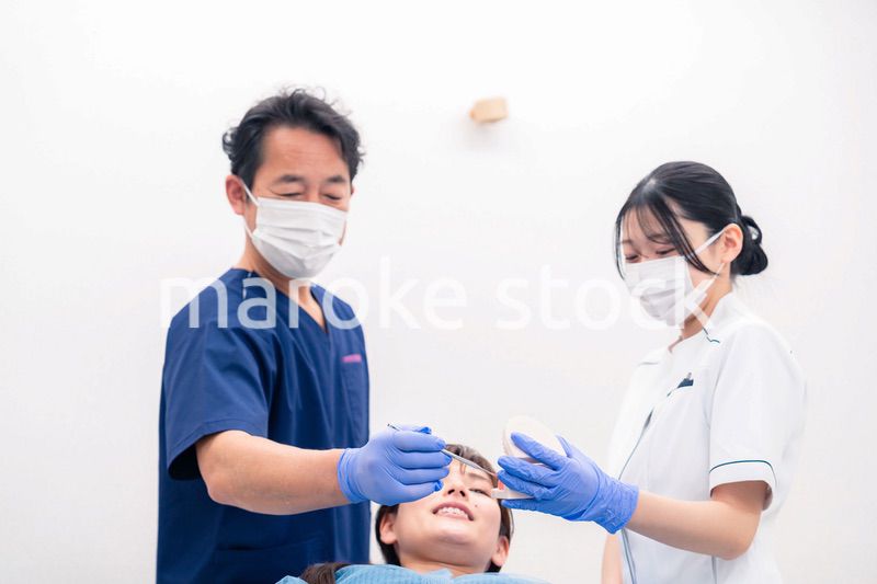 模型を使って患者に治療方針を説明する歯医者さん