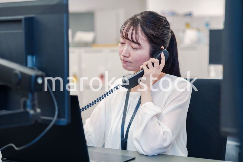 お客様からの電話に困惑をする若い女性オペレーター