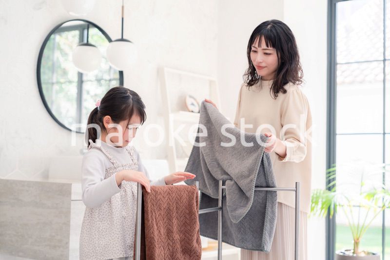 洗濯物干しをお手伝いする小さな女の子