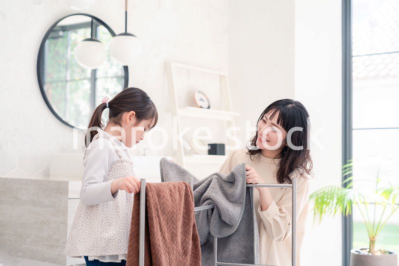 洗濯物干しをお手伝いする小さな女の子