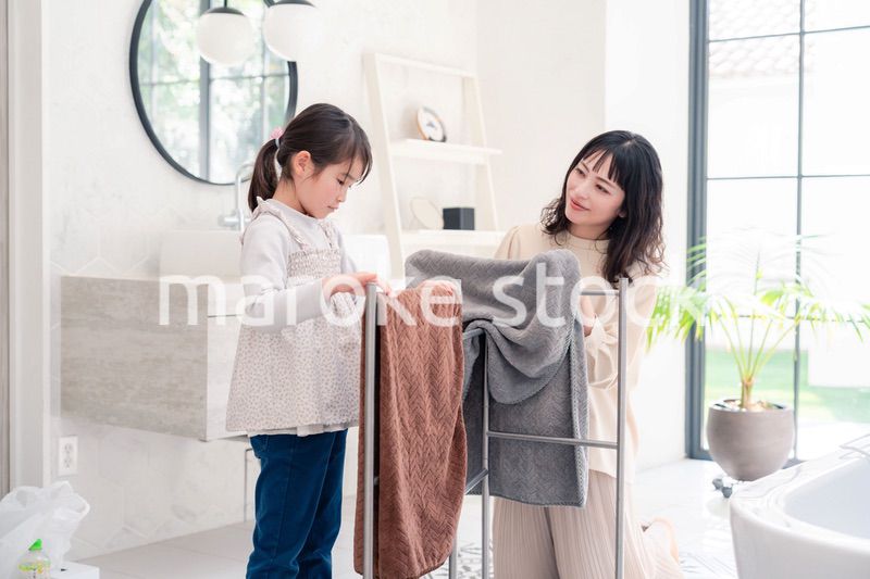 洗濯物干しをお手伝いする小さな女の子