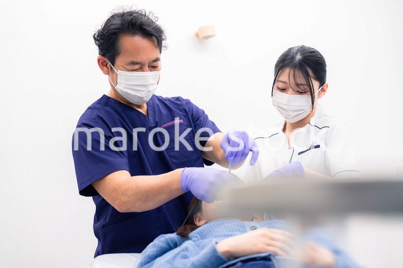 歯科治療をする歯科医師と歯科助手