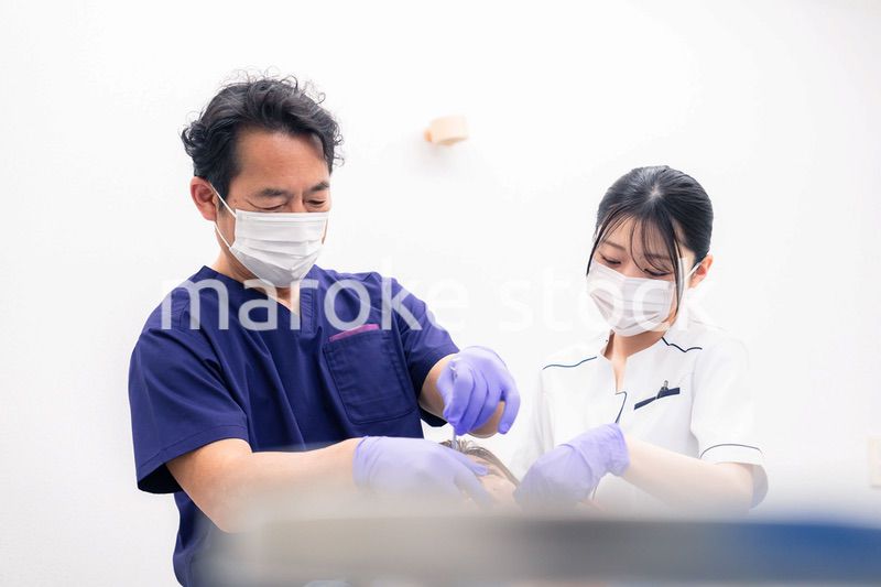 歯科治療をする歯科医師と歯科助手