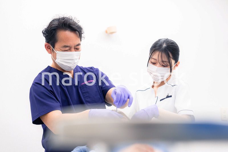 歯科治療をする歯科医師と歯科助手