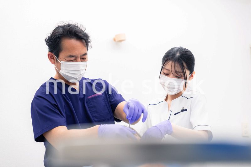 歯科治療をする歯科医師と歯科助手