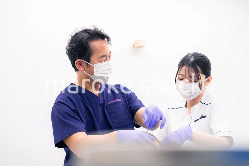 歯科治療をする歯科医師と歯科助手