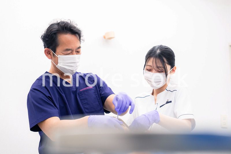 歯科治療をする歯科医師と歯科助手