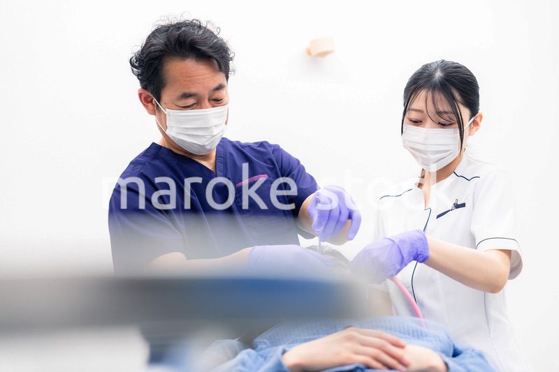 歯科治療をする歯科医師と歯科助手