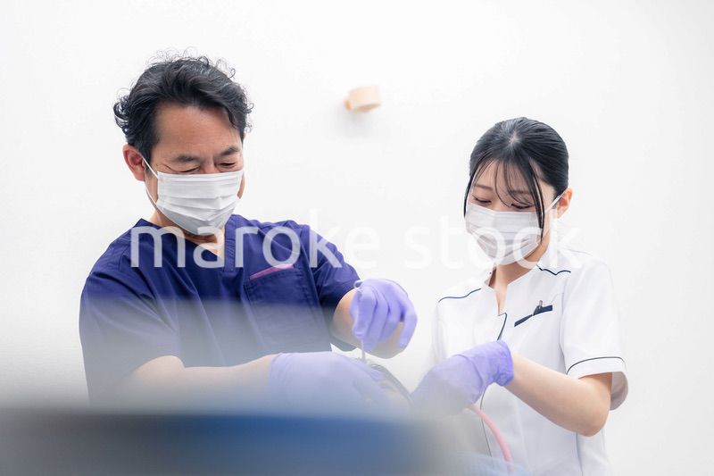 歯科治療をする歯科医師と歯科助手