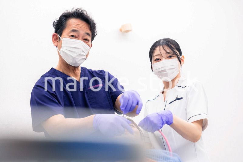 歯科治療をする歯科医師と歯科助手