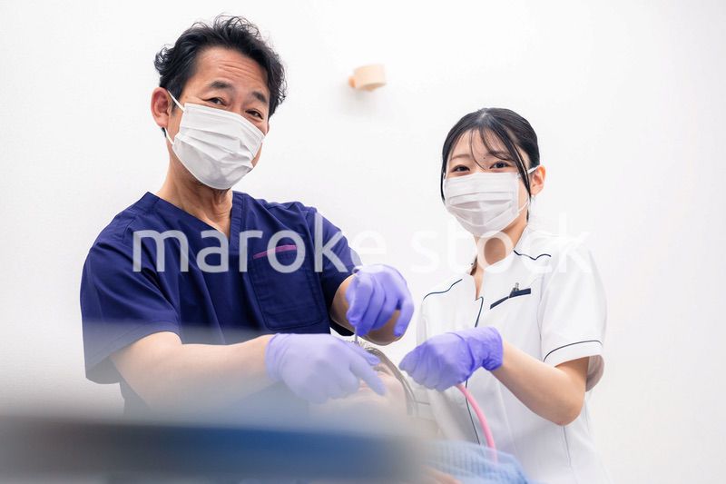 歯科治療をする歯科医師と歯科助手