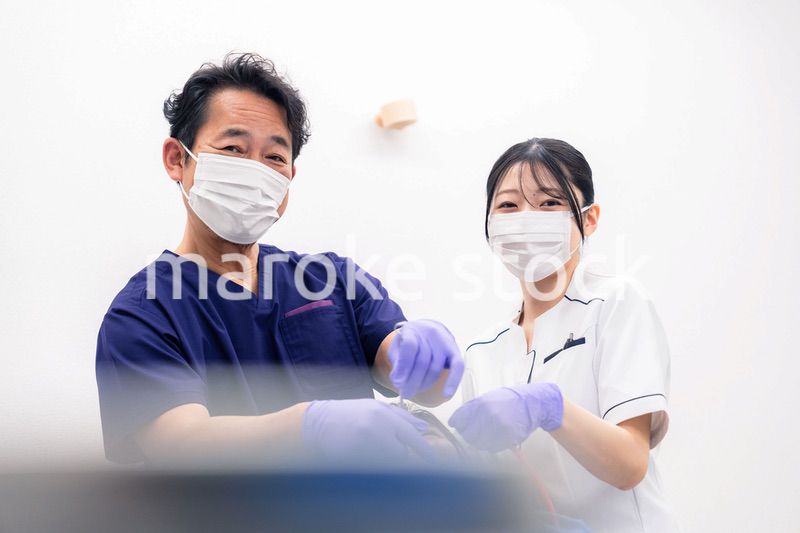 歯科治療をする歯科医師と歯科助手