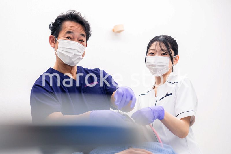 歯科治療をする歯科医師と歯科助手