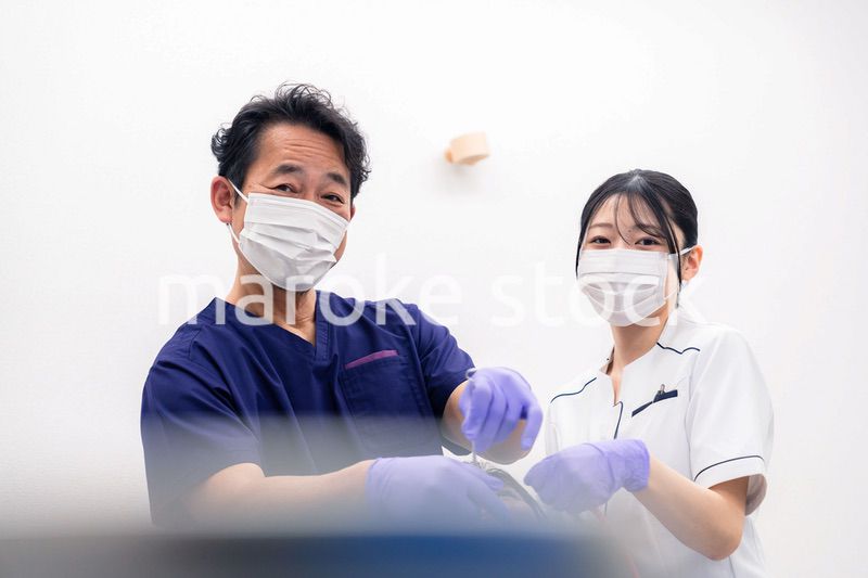 歯科治療をする歯科医師と歯科助手