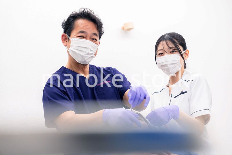 歯科治療をする歯科医師と歯科助手