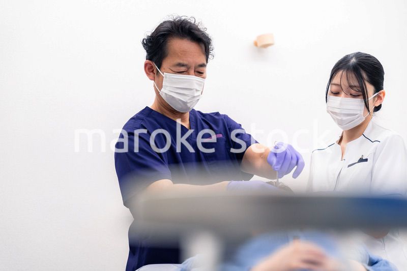 歯科治療をする歯科医師と歯科助手