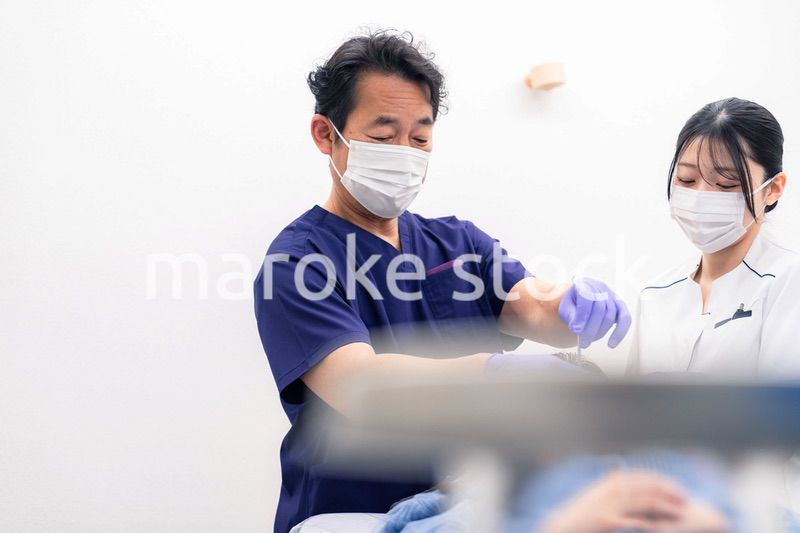 歯科治療をする歯科医師と歯科助手