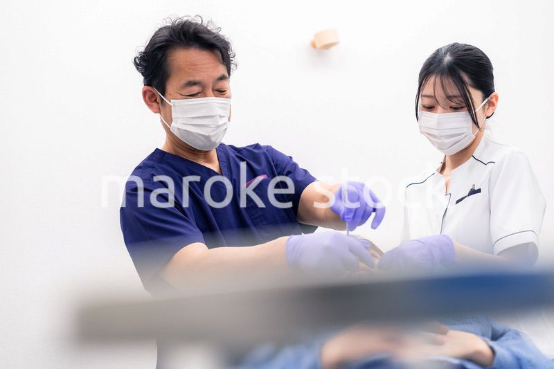 歯科治療をする歯科医師と歯科助手