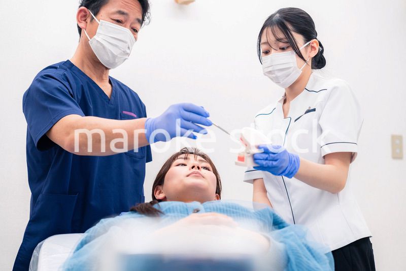 模型を使って患者に治療方針を説明する歯医者さん