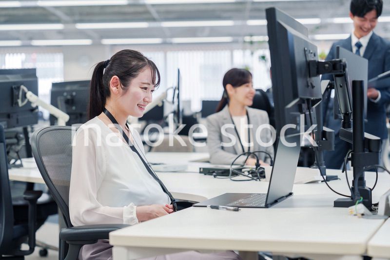 オフィスでデスクワークをする妊婦の女性