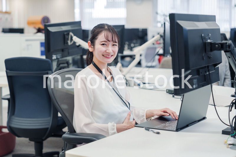 オフィスでデスクワークをする妊婦の女性