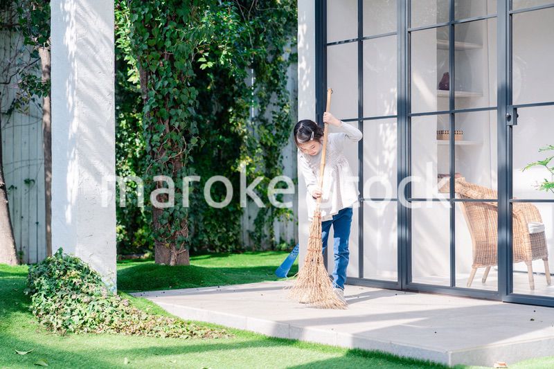 家の外の掃除を手伝う女の子