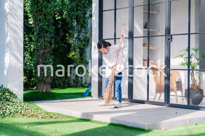 家の外の掃除を手伝う女の子