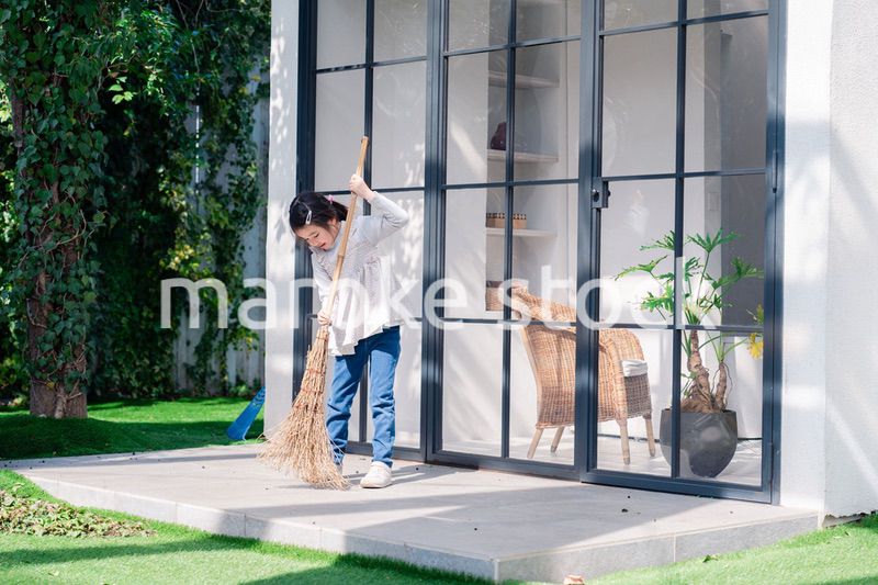 家の外の掃除を手伝う女の子