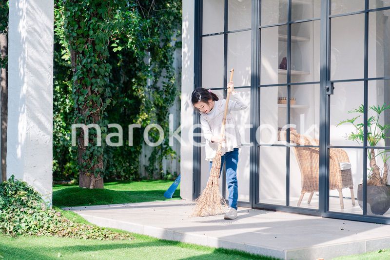 家の外の掃除を手伝う女の子