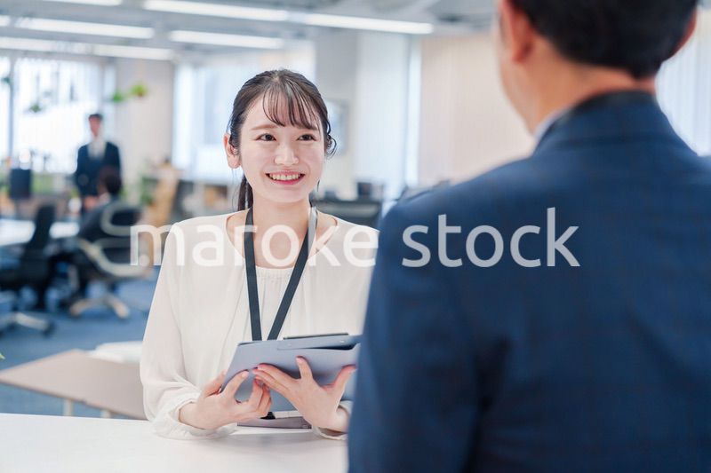 窓口で来客の対応をする女性スタッフ