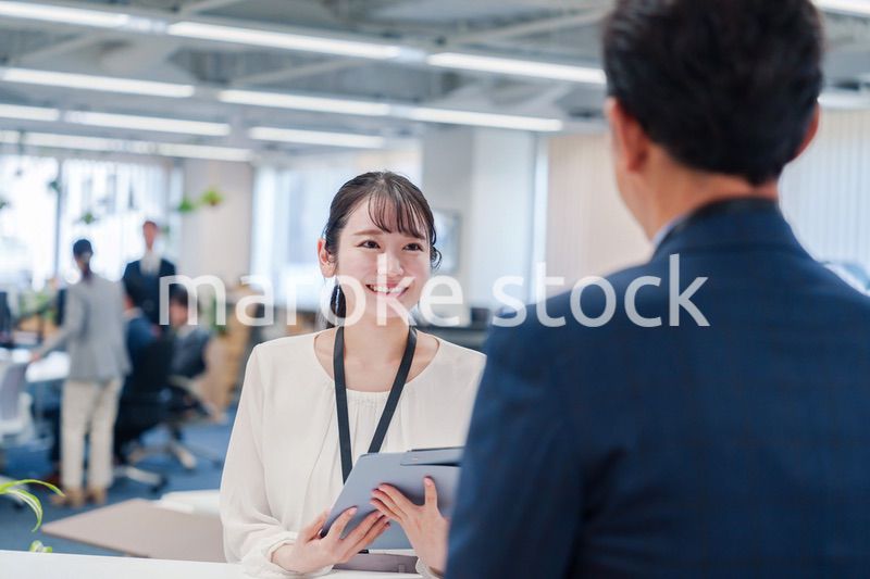 窓口で来客の対応をする女性スタッフ