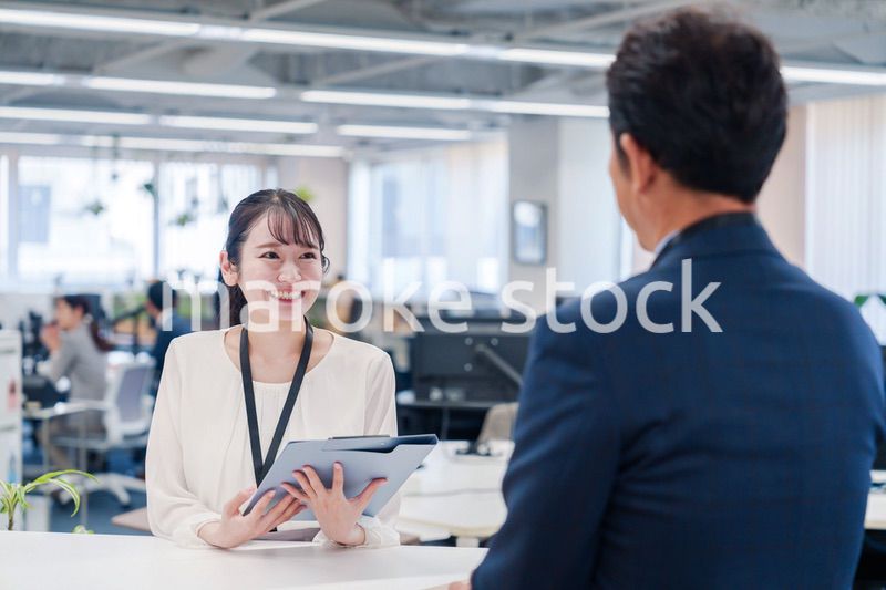 窓口で来客の対応をする女性スタッフ