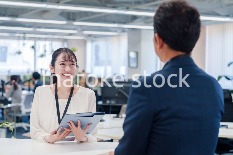 窓口で来客の対応をする女性スタッフ