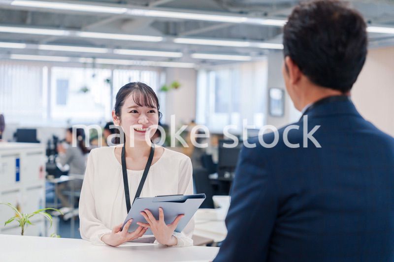 窓口で来客の対応をする女性スタッフ