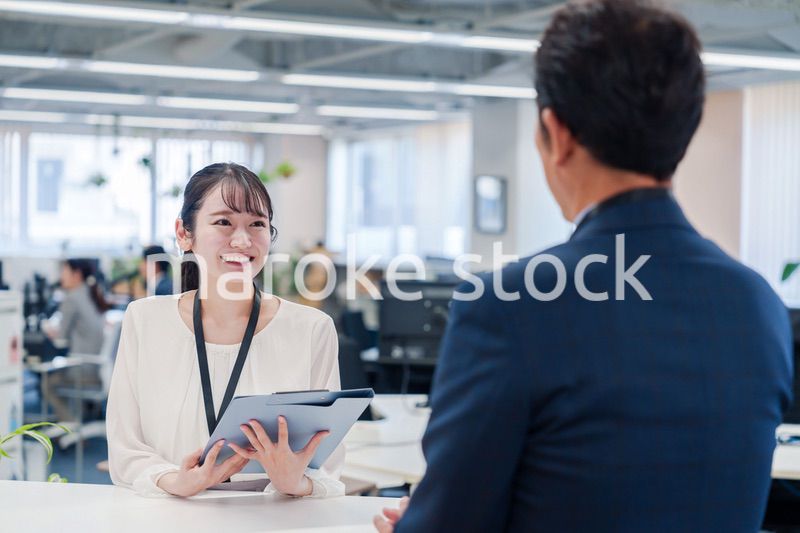 窓口で来客の対応をする女性スタッフ