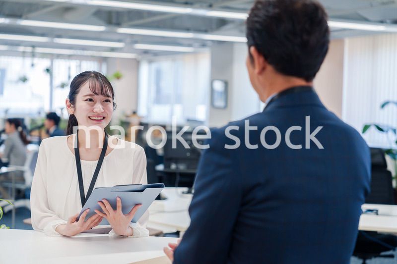 窓口で来客の対応をする女性スタッフ