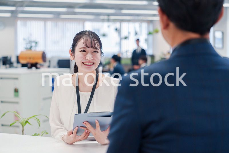 窓口で来客の対応をする女性スタッフ